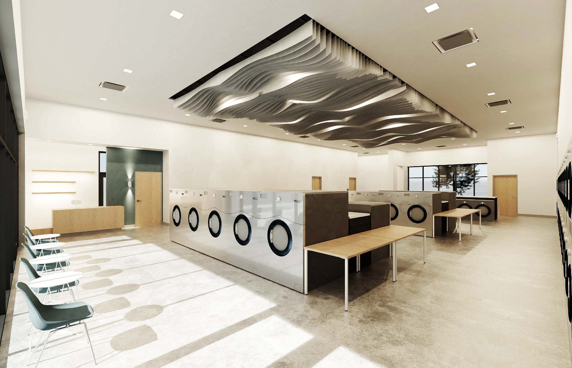 Inside The Laundery: rows of front-load washers, folding tables and seating